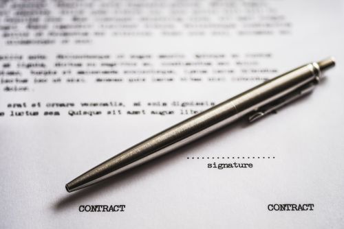 Picture of a contract with a silver pen to sign.