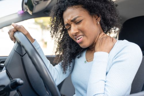 One black woman in the car with neck pain Concept for Should I Get Medical Treatment After A Car Accident?
