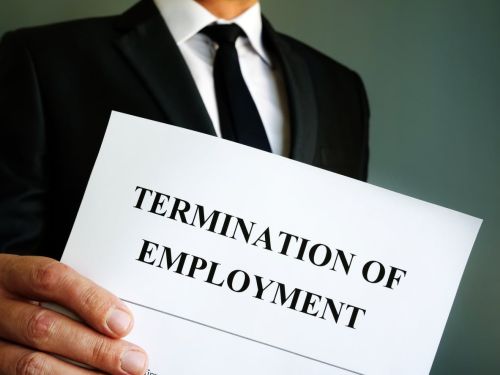 Man is holding Termination of employment papers. Visual concept for legal blog titled: Wrongful Termination Lawsuits: How to Defend Your Company.